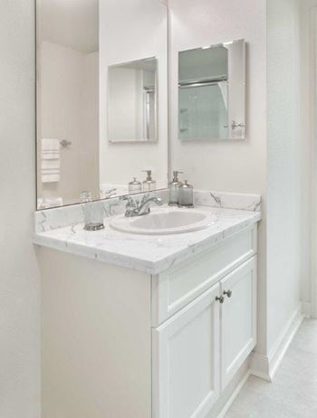 a white bathroom with a sink and a mirror